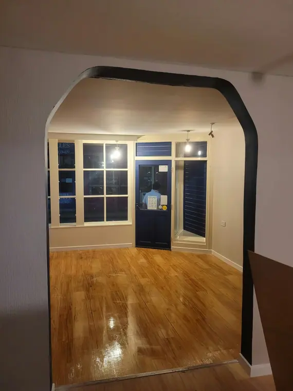 Through the arch to the front room and its bay window.
